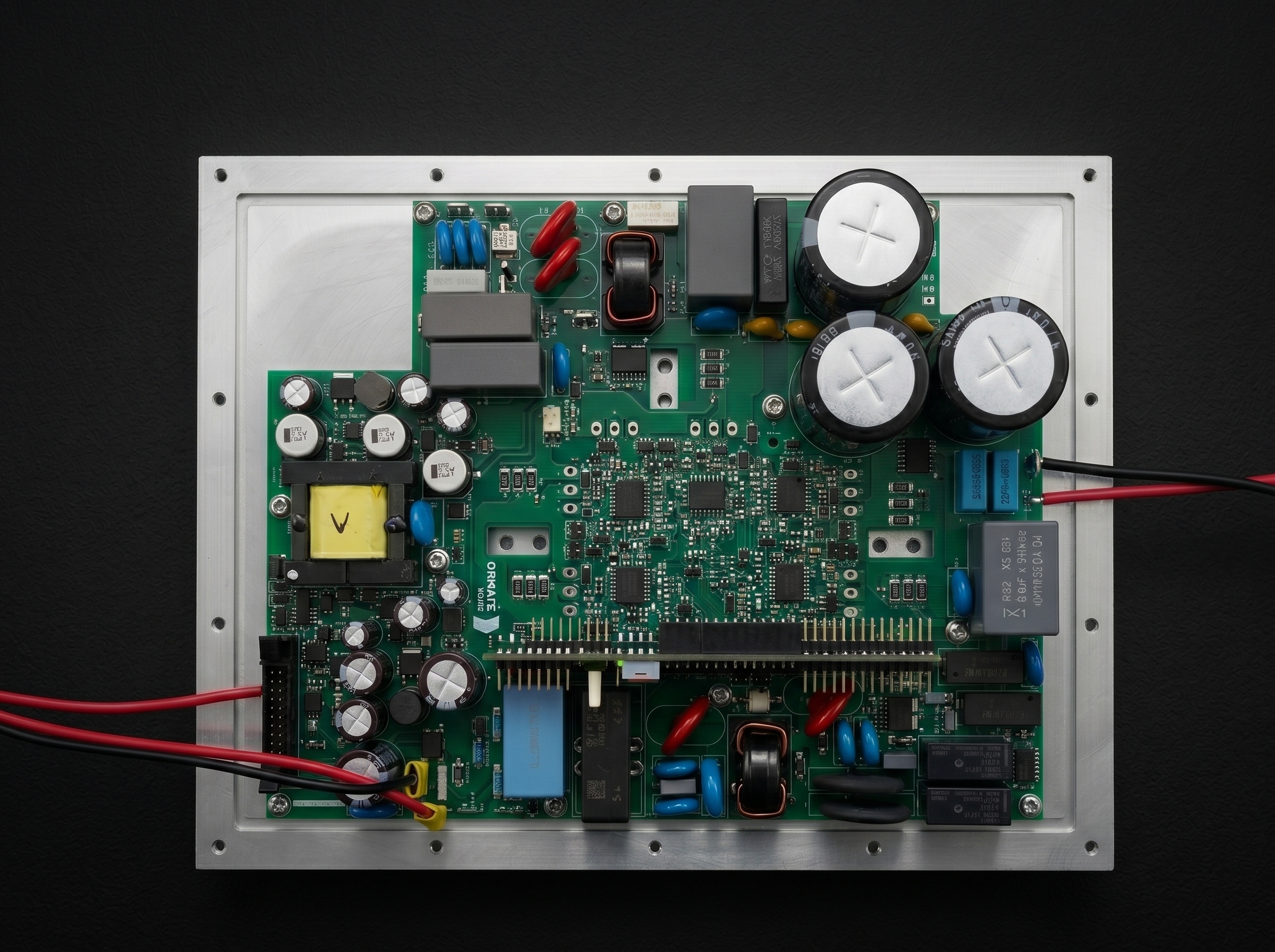 Chassis-mounted Ornate power-electronics board on a dark studio background — capacitor bank and digital control stage